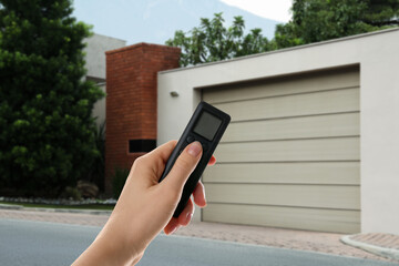 Woman using remote to control garage door outdoors, closeup
