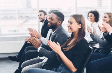 Group of business people applauding speaker after presentation in conference room