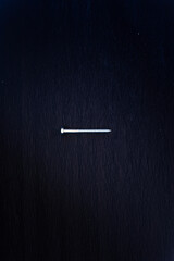 one nail on the black background, carpentry 