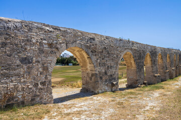 Larnaca, Cyprus, 8 May 2025, The ancient Kamares Aqueduct stretches across the landscape under a clear sky in Larnaca, Cyprus.