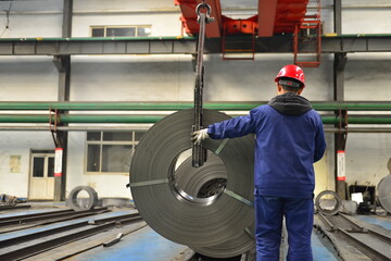 Workers on the production line of the strip steel coil factory are working