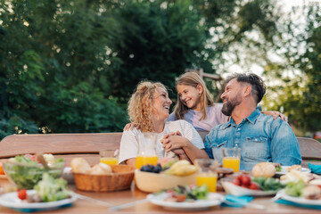 Happy family enjoying backyard meal together