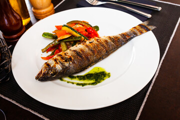 Delicious fish dish - baked sea bass with stewed vegetables. High quality photo