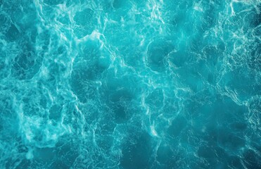 Close-up view of vibrant blue ocean water surface with swirling waves and foam creating dynamic texture