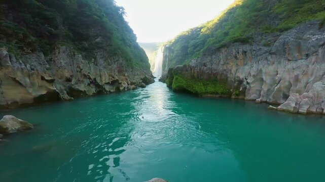 Turquoise water flowing through tamul waterfall canyon in san luis potosi