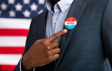 Patriotic elections in America 2020. African American US resident showing with finger on...