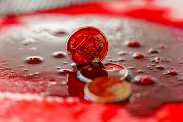 Drops of blood fall on euro coins close-up. Bloody criminal finance.Macro Shot of Euro Coins in...