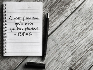 A year from now you'll wish you had started today text written on book background. Stock photo.