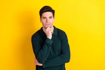 Stylish young man in green polo shirt posing confidently against a vibrant yellow background with a...