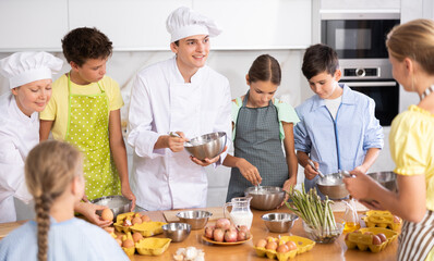 Teenage children are interested in learning in culinary courses under the supervision of two adult chefs