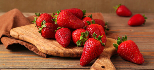 Board with sweet fresh strawberries on wooden table