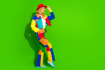 Stylish young woman in bold colorful attire smiling confidently against a bright green background, showcasing trendy summer fashion