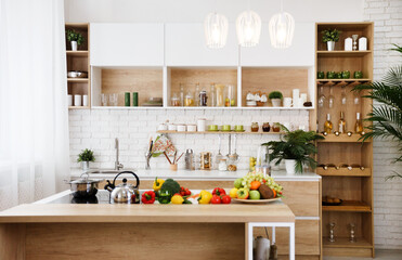 Wooden kitchen interior with island and big table. Fruits and vegetables on table