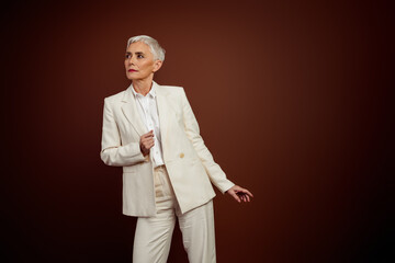 Confident mature businesswoman wearing a stylish white suit, exuding elegance and professionalism