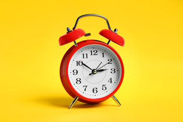 One red alarm clock on yellow background