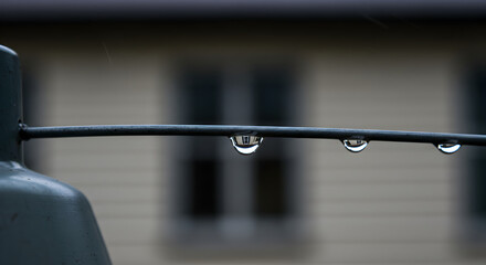 Reflective Raindrops Suspended On Wire With Blurred Home Facade Backdrop