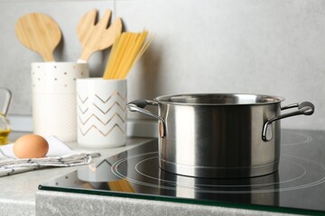 Cooking pot on cooktop indoors. Kitchen utensil