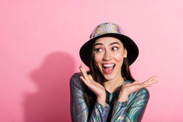 Lovely young woman in stylish getup posing playfully against a pink background creating a cheerful and lively atmosphere.