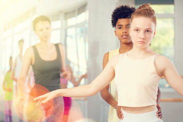 Couple teen boy and teen girl perform paired ballet dance in studio
