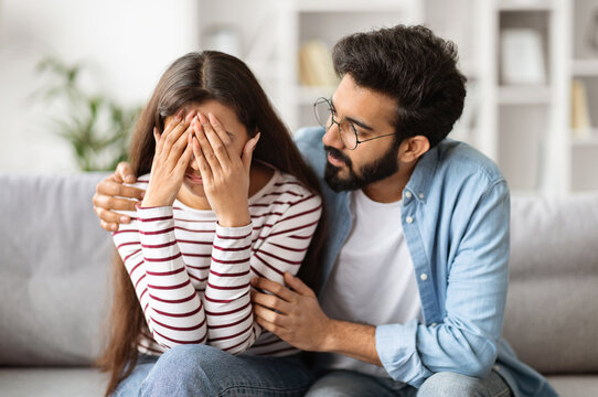Loving husband indian man comforting consoling upset crying wife woman, giving psychological support care compassion, helping sharing grief or problem, miscarriage, empathy in couple relationships