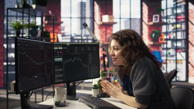 Joyful thrilled woman works on stock trading analysis browsing real time data on her monitors. The digital platform provides financial statistics, forex trends and investment insights. Camera A.