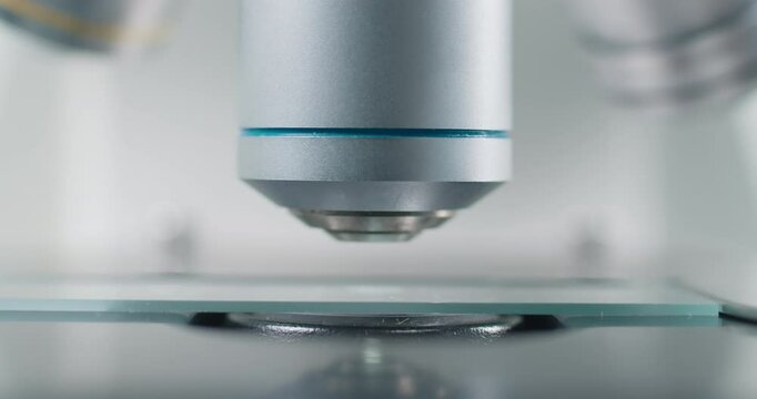Close-up of scientific microscope with glass, analyzing data in lab, research for vaccine production. Concept of biological sciences and virology. 