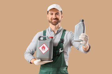 Male mechanic with canisters on beige background