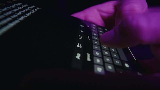 Close-Up Of Fingers Typing Notes On Smartphone In Purple Light