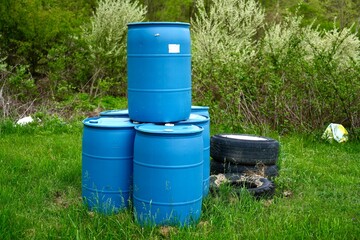 Blue Plastic Barrels and Tires on Grass Field