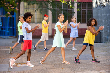 Obraz premium Children exercising contemporary dance moves during their outdoor rehearsal.