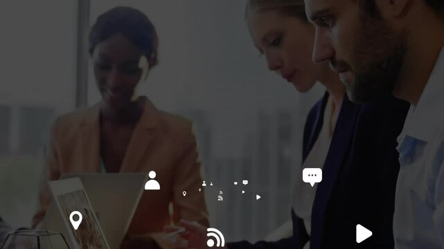 Team collaborating over laptop around desk in tech office, showing floating chat and location icons