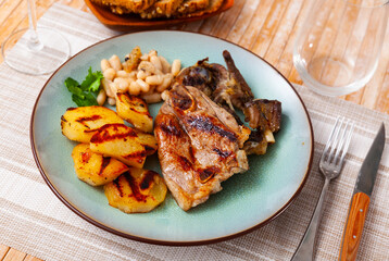 Appetizing lamb stew with boiled potatoes and white beans closeup