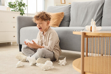 Sick little boy with tissues suffering from allergy at home