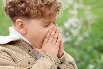 Sick little boy suffering from allergy outdoors