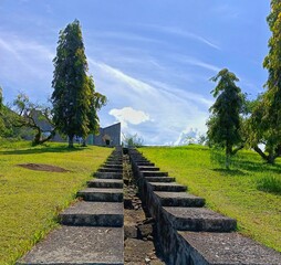 Walking Up Stone Steps on Green Hill Under Blue Sky