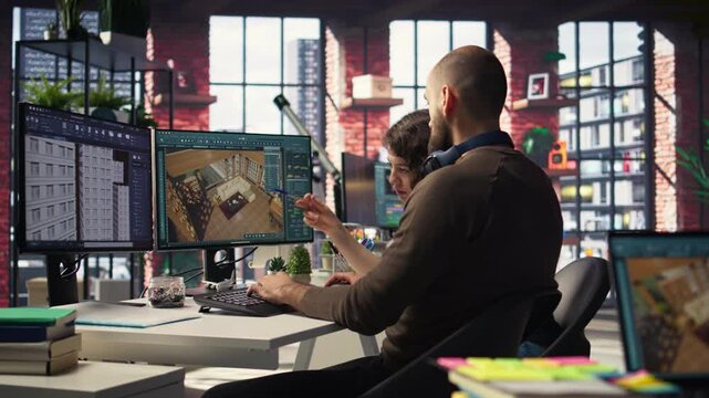 Designers team works on remodeling project using architectural software on PC to configure room layouts. Program allows to drag and drop elements or assets, adjusting virtual furniture. Camera A.