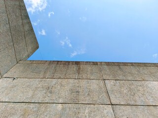 Fototapeta premium Stone Wall Meeting Blue Sky and Clouds Architecture Detail