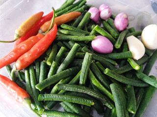 Top view of ingredients for making stir-fried long beans include long beans, onions and cayenne pepper. Food preparation concept.