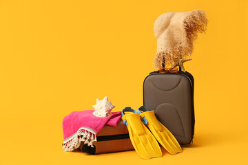 Suitcases, stylish straw hat, flippers and sunglasses on color background © Pixel-Shot