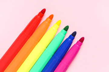 Colorful felt-tip pens on pink background, closeup. LGBT concept