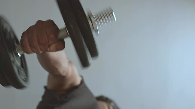 Man doing supination and pronation with dumbbell seen from below. Forearm exercise