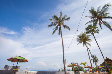 The beauty and comfort of the tropical beach of Lasiana Beach in Kupang City, East Nusa Tenggara, Indonesia. With umbrellas, coconut trees and sunny weather.