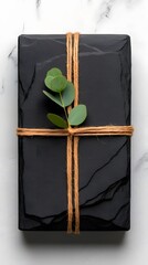Black Slate Gift Box with Eucalyptus Leaves on Marble Surface