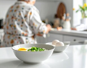 Naklejka premium Delicious Bowl of Rice with Egg and Green Onions in Cozy Kitchen Setting with Person Cooking