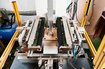 Innovative semi-automatic machine efficiently wraps rectangular boxes in a modern packaging facility