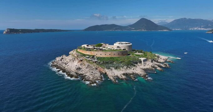 Aerial pullback of Mamula Island and surrounding Adriatic Sea on a sunny clear day in Montenegro