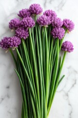 Fototapeta premium Fresh bunch of purple chives on marble