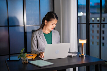 Alone Working Late at Night. Asian business woman at workplace in office late night work at a desk...