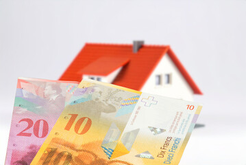 A modern house and Swiss franc banknotes