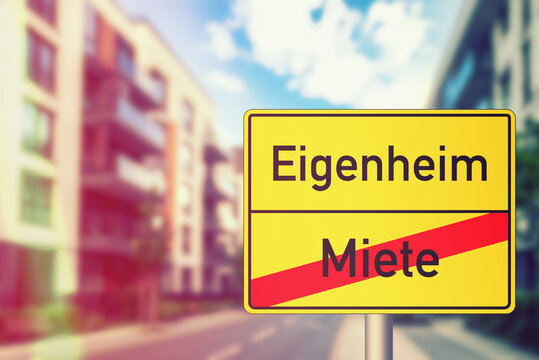 Moderne Mehrfamilienh&auml;user und ein gelber Schild Ende Miete Anfang Eigenheim